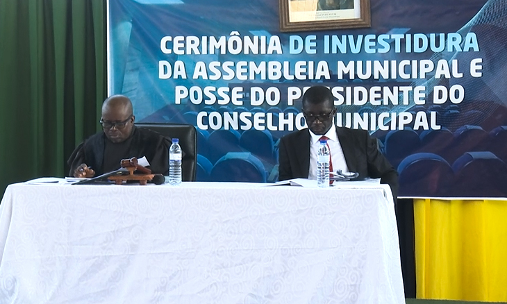 Manuel de Araújo, Chief Judge of Zambézia, presiding over a group of people sitting at a table in front of a podium.